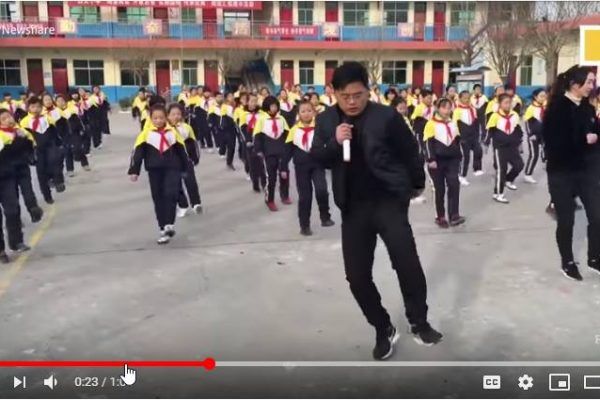 Video of a head teacher in China helping his students exercise using dance in the playground